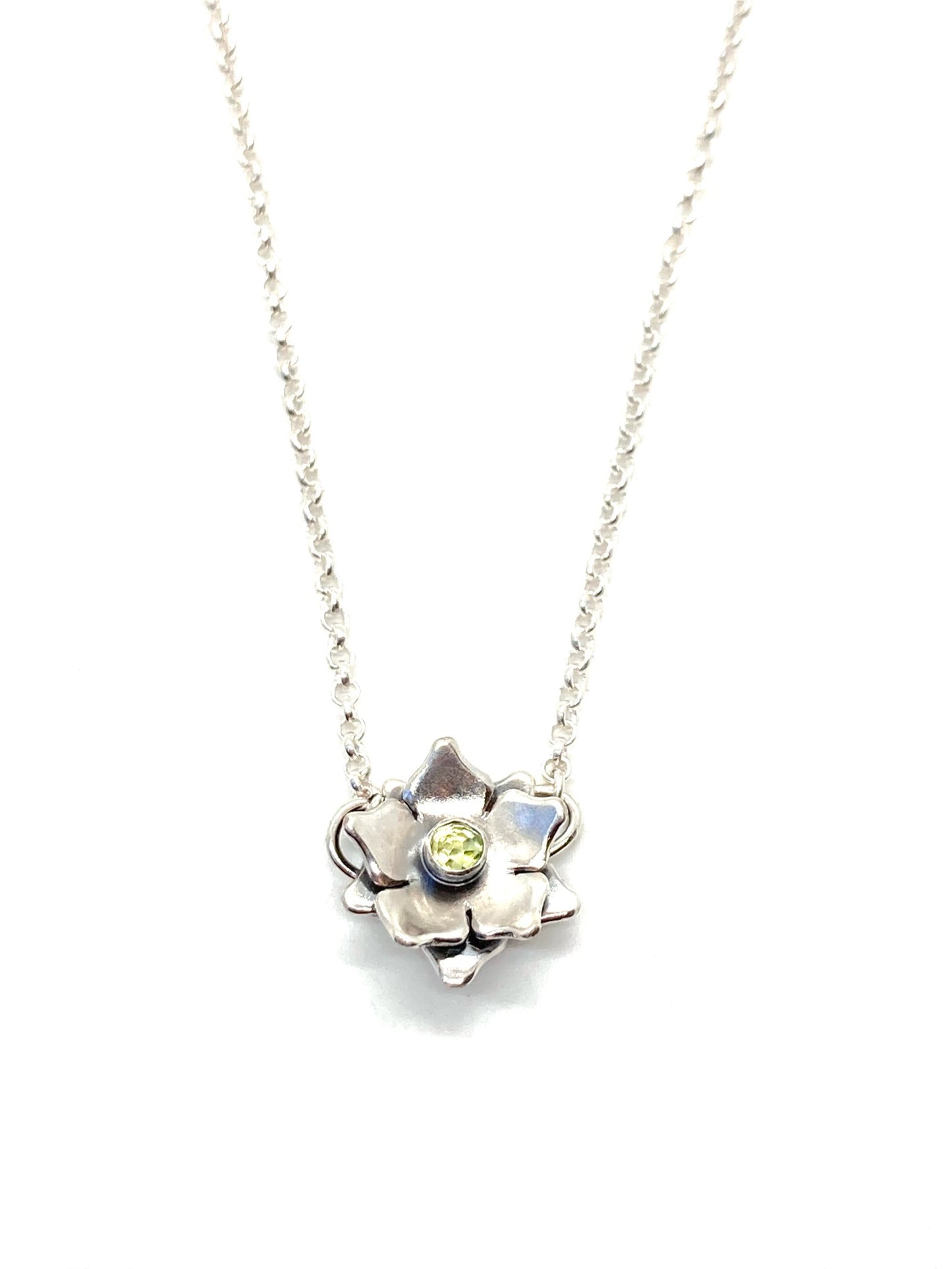 A sterling silver floral necklace with a light green gemstone at its center, attached to a chain.