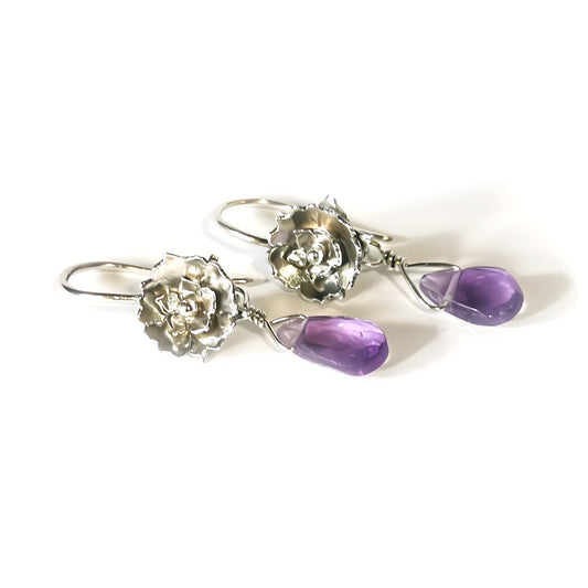 Silver flower earrings with purple gemstones on a white background