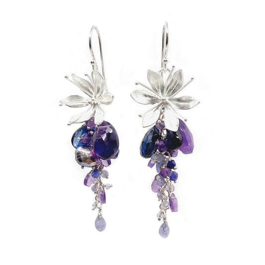 Flower-shaped earrings with purple and blue beads on a white background
