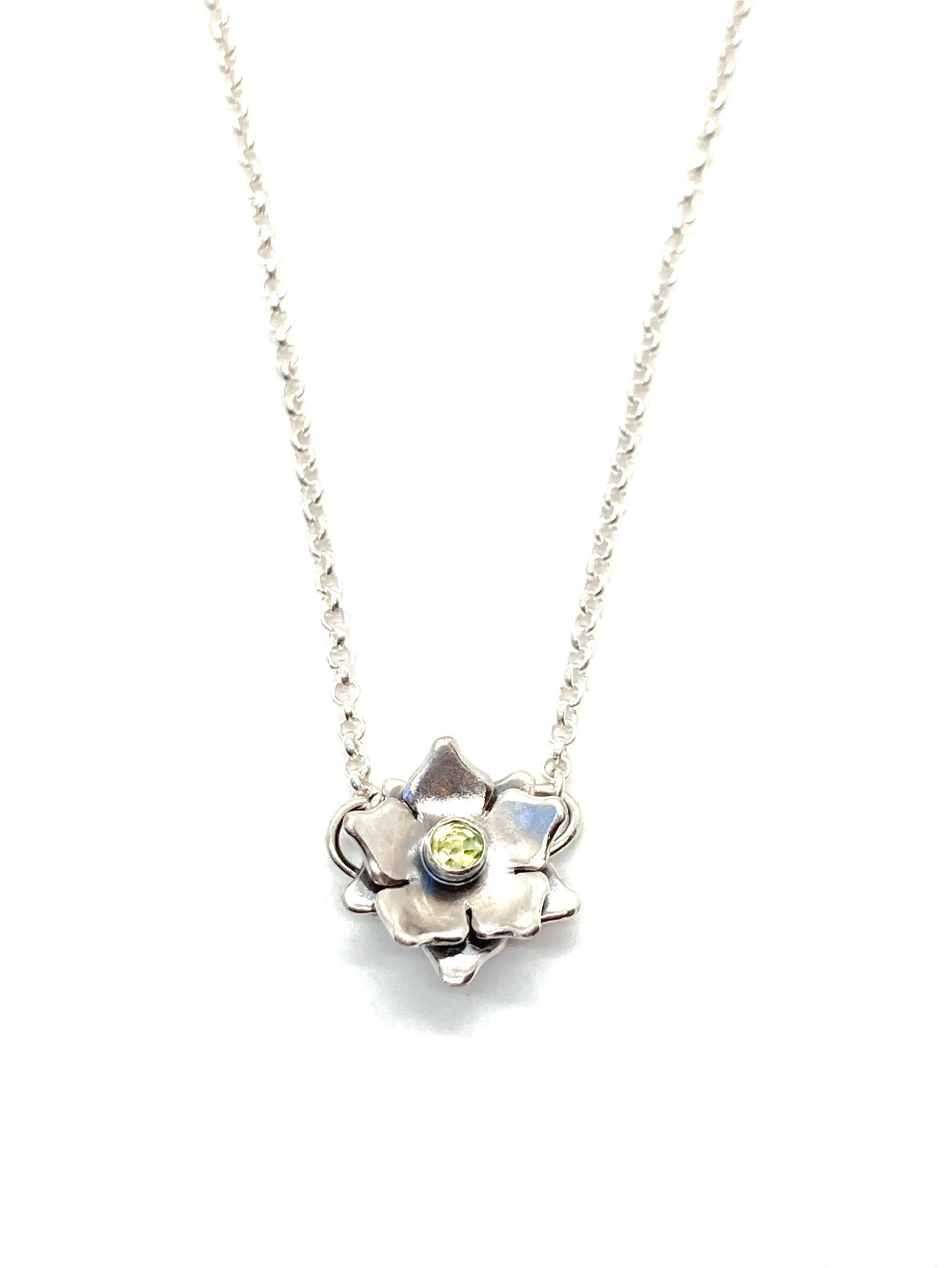 A sterling silver floral necklace with a light green gemstone at its center, attached to a chain.